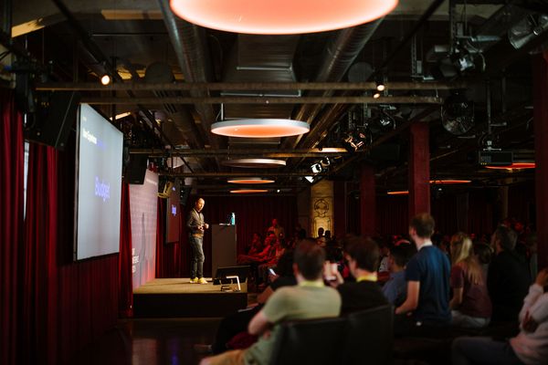 Referat/Konferenz im Papiersaal, Redner auf Bühne, Menschen sitzen 