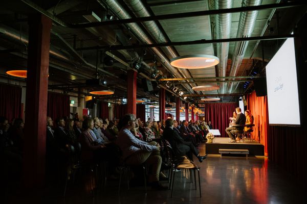 Referat/Konferenz im Papiersaal, Bühne mit Gasten, Personen sitzen 
